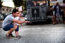 Un papa et son enfant jouent à la pétanque en extérieur sur un parking goudronné