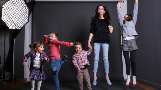 Des enfants sautent tous ensemble dans un studio de photo