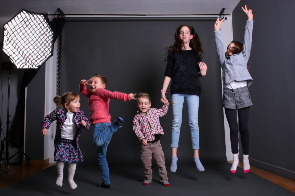 Des enfants sautent tous ensemble dans un studio de photo
