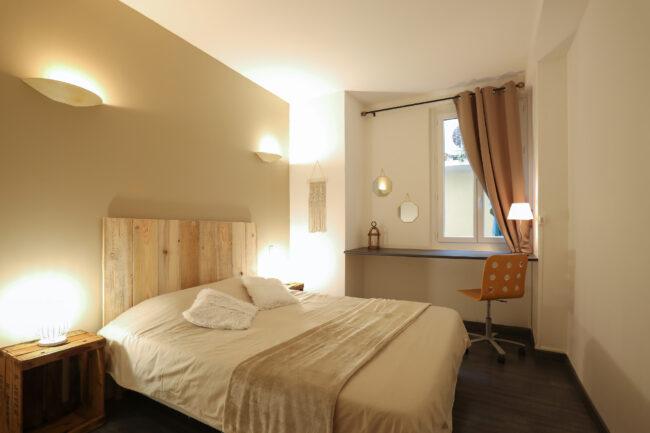 Chambre à louer, lit double, tête de lit faite en bois de récupération