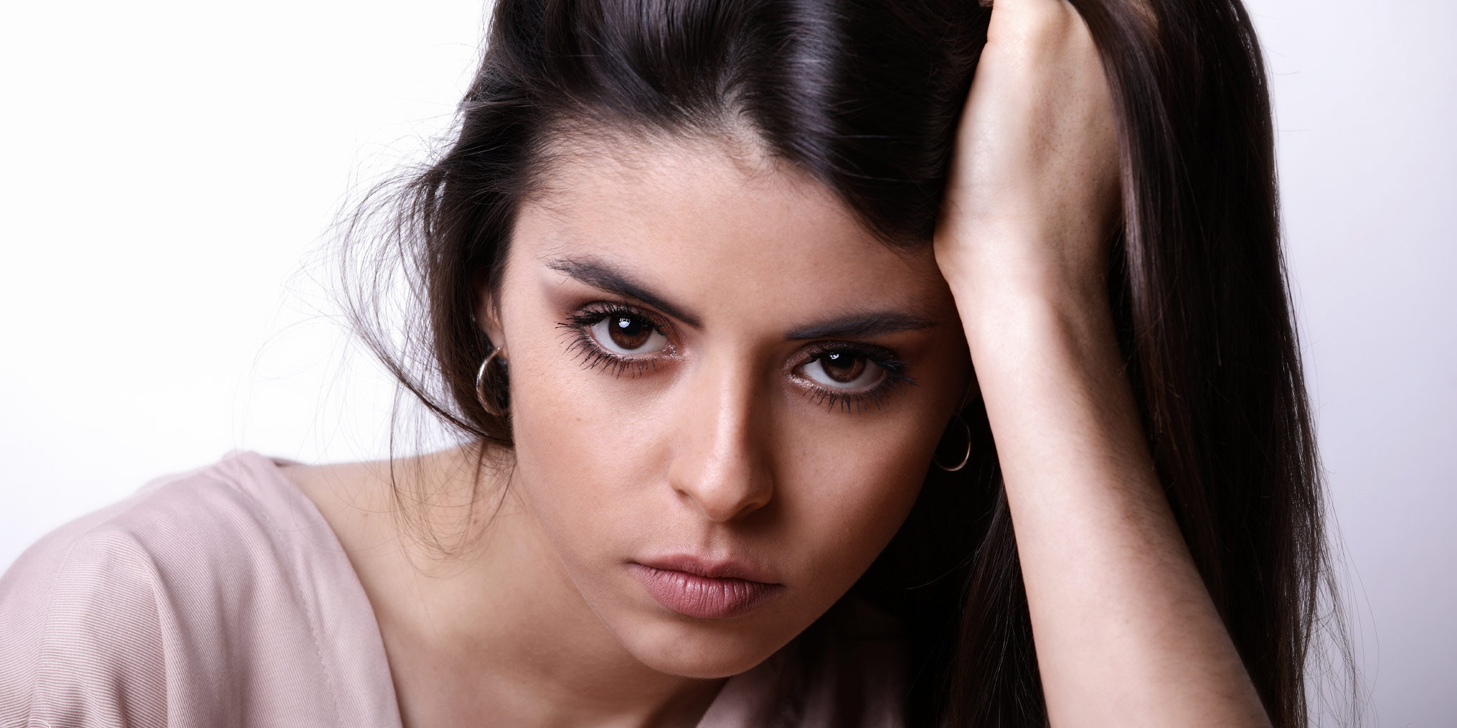 Portrait visage de Jennyfer, jeune modèle photo féminin, la main dans les cheveux.