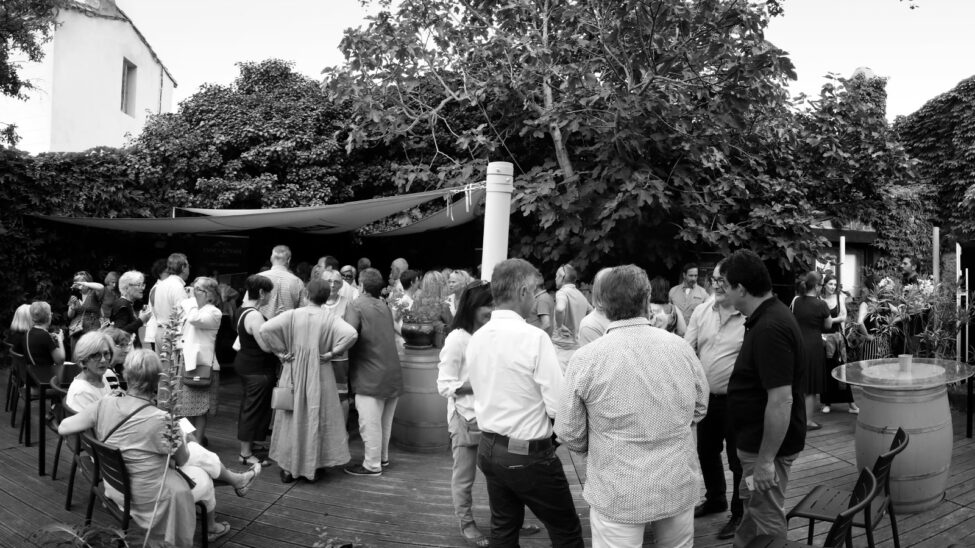 Cocktail en plein air un parquet en bois avec un vaste public qui discute entre eux