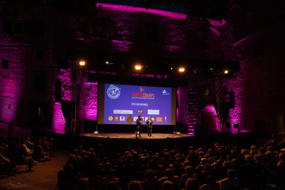 Mathieu Amalric, Yves Jeuland à ses côtés, sur scène de nuit face à un immense public dans la cours du Château Comtal de la Cité de Carcassonne