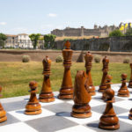 Un jeu d'échec géant sur la pelouse de l'hôtel avec au loin la Cité de carcassonne