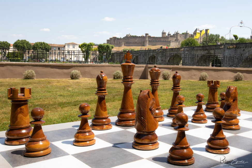 Un jeu d'échec géant sur la pelouse de l'hôtel avec au loin la Cité de carcassonne
