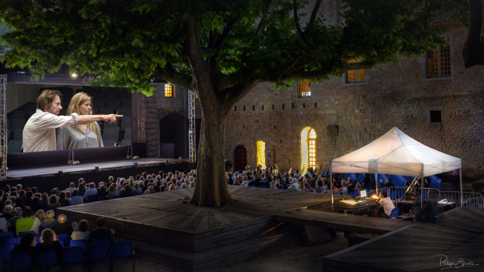 Projection en plein air de nuit sur grand écran d'un documentaire dans la cour du midi du Château Comtal de la Cité de carcassonne