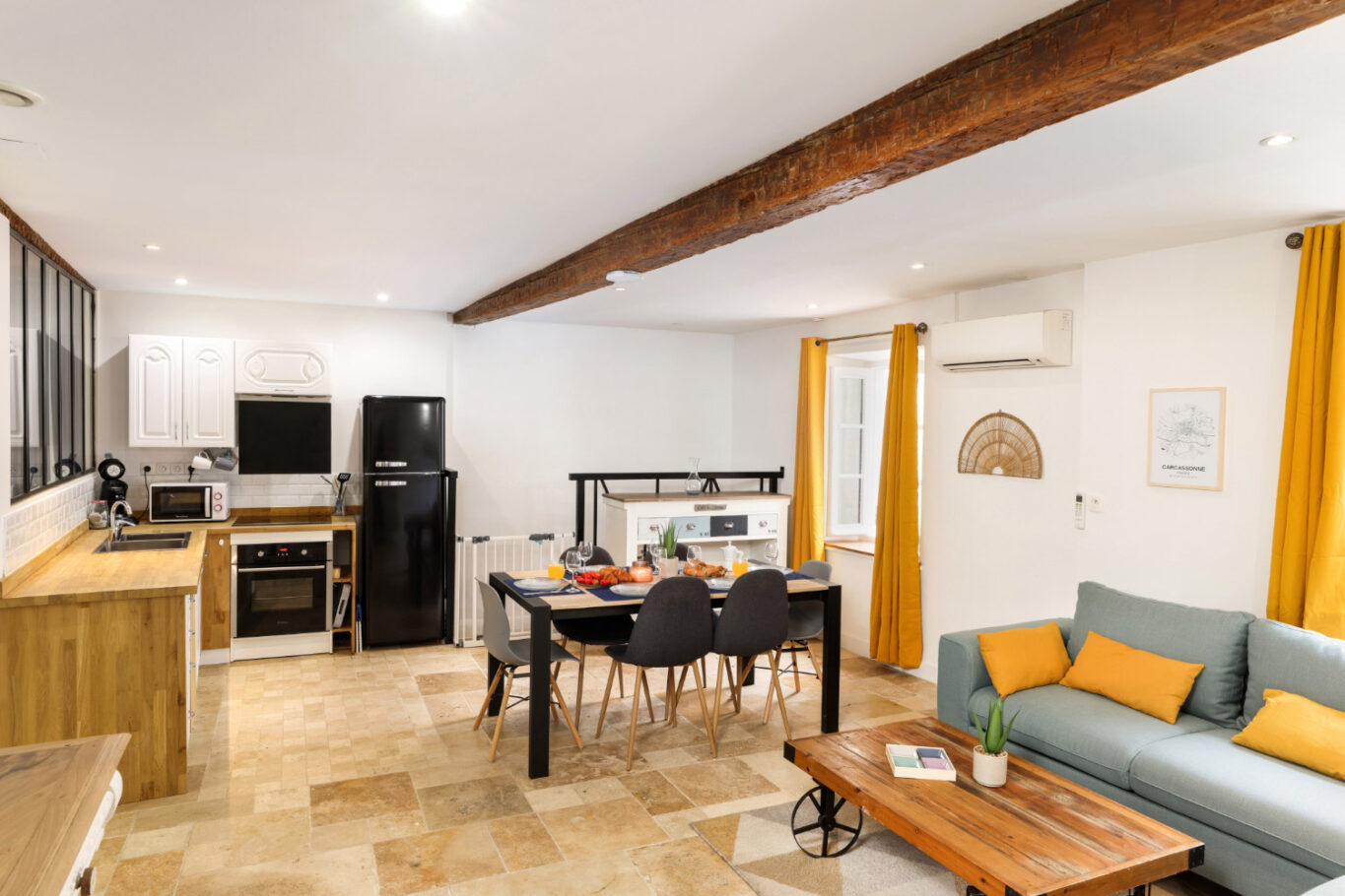 Salon moderne avec cuisine ouverte, coin repas et canapé confortable