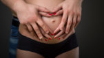 Deux mains posées sur le ventre d'une femme enceinte qui forment un coeur