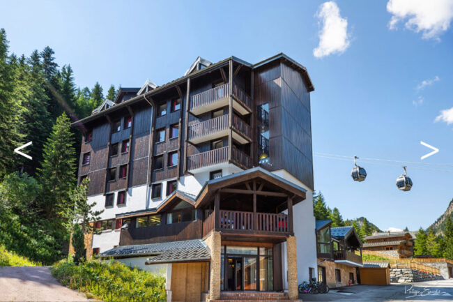 Un hôtel avec un télésiège devant, prêt à accueillir les amateurs de ski et de montagne