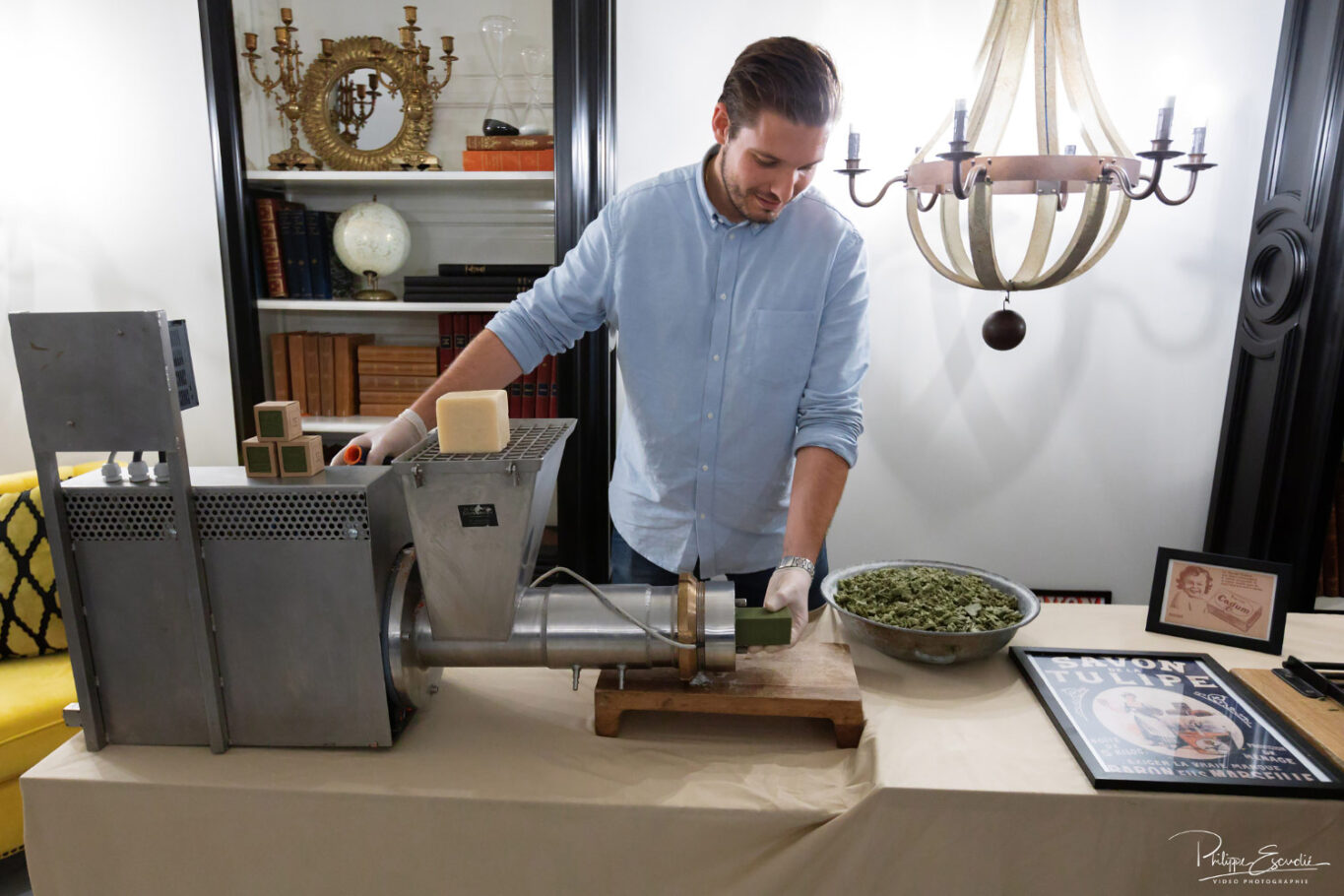 Un homme actionne une machine à faire du savon et en sort un bloc