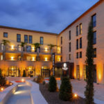 Entrée de l'hôtel Hilton à la tombée de la nuit, façade éclairée