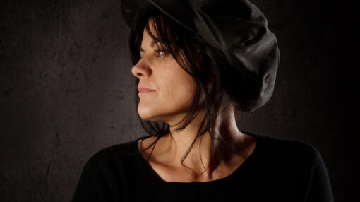 portrait de trois quart d'une femme portant une casquette, atmosphère pénombre, lumière chaude