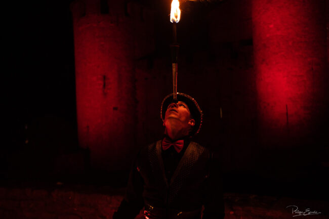 jongleur avec une torche enflammée sur le visage de nuit