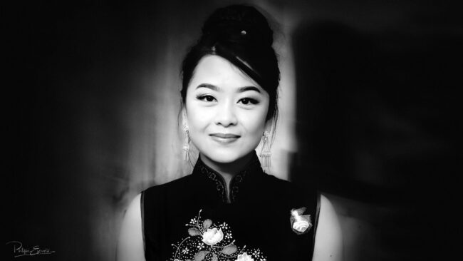 Portrait noir et blanc de face d'une jeune fille asiatique qui sourit
