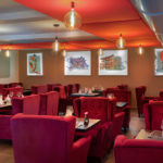 Salle du restaurant du Japon avec de grands fauteuils pourpres et des tables noires