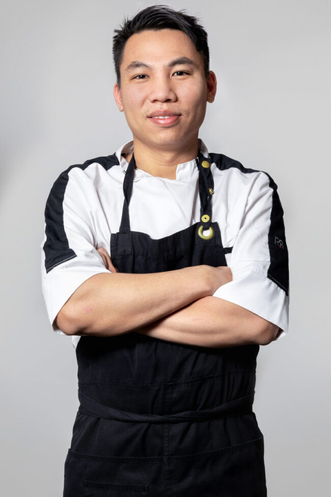 Portrait de face d'un chef cuisinier asiatique les bras croisés