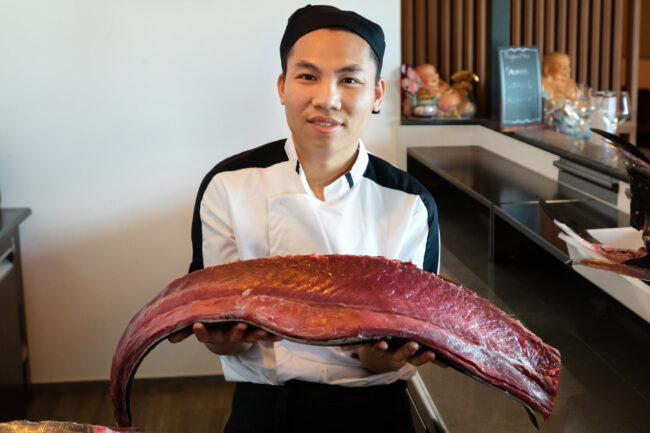 Filet d ethon tenu dans les mains d'un cuisinier asiatique