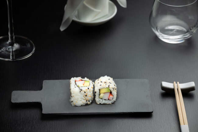 deux naka makis saumon poulet posés sur une ardoise