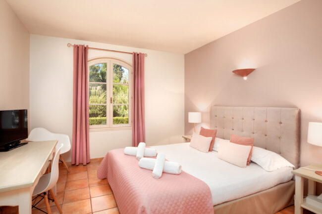 chambre avec lit blanc et parure rose