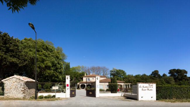 Portail d'entrée d'un hôtel avec bâtisse derrière