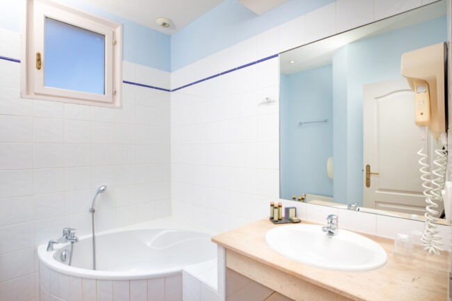 Baignoire en demi cercle et evier d'une salle de bain d'hôtel