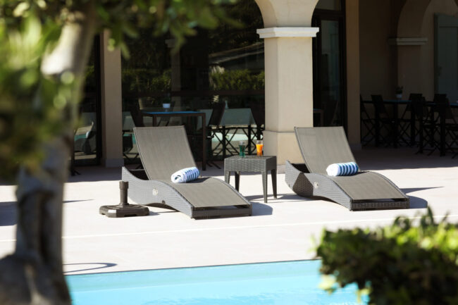Deux transats avec piscine en premier plan
