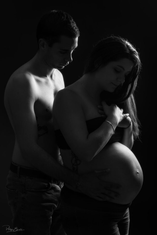 un homme et une femme enceinte de profil en ambiance clair obscur