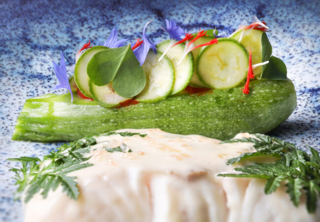 Dans les cuisines du Puits du Trésor, Lastours 9 Détail d'un mini concombre avec dessus des pétales de fleurs mauve et rouge