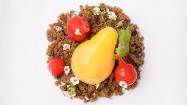 Dans les cuisines du Puits du Trésor, Lastours 2 une assiette blanche vue de dessus avec dedans trois mini tomates rouge et une tomate jaune en forme de poire