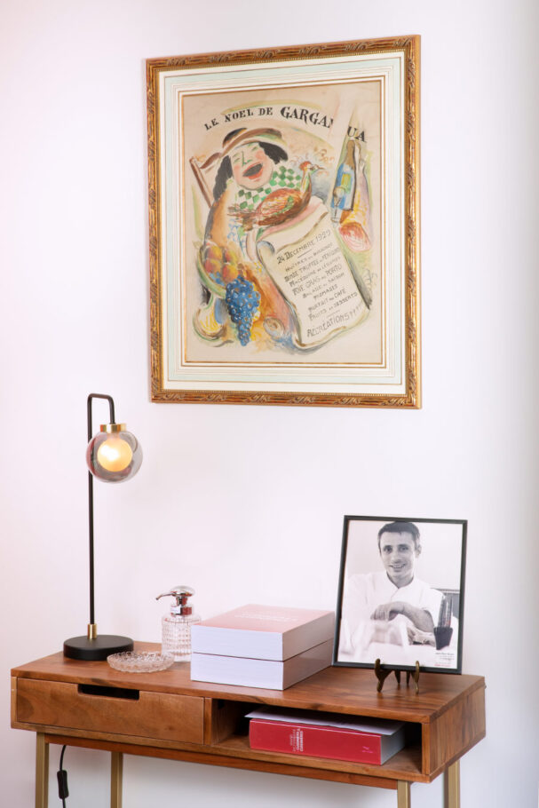 Table avec dessus un luminaire et le portrait d'un chef cuisinier dans un cadre photo