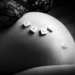 ventre d'une femme enceinte avec dessus des lettres de scrabble formant le mot lily