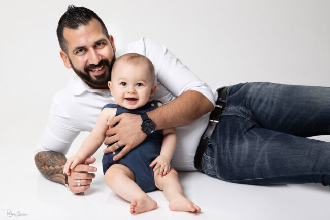 En famille, formule box cadeau ! 12 Un homme barbu est allongé avec un bébé souriant devant lui