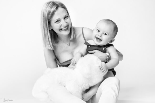 En famille, formule box cadeau ! 13 Une mère assise tient dans ses mains un bébé qui sourit