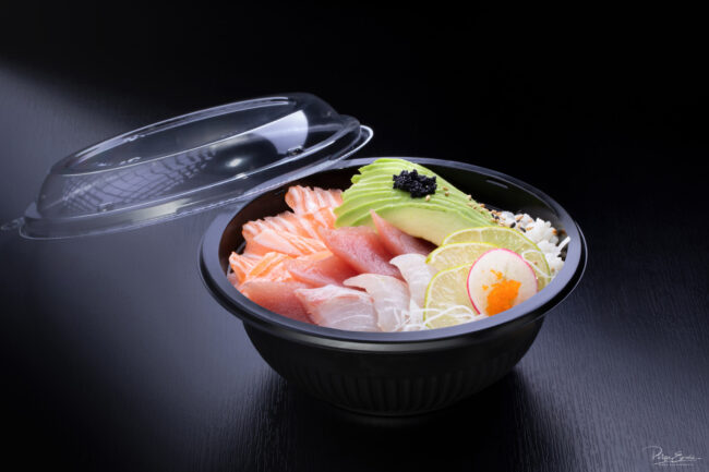 Shooting culinaire pour le restaurant An Sushi 13 Sur une table noire, un chirashi, dans un bol noir, composé de tranches de thon, de saumon, de daurade et de lamelles d'avocat