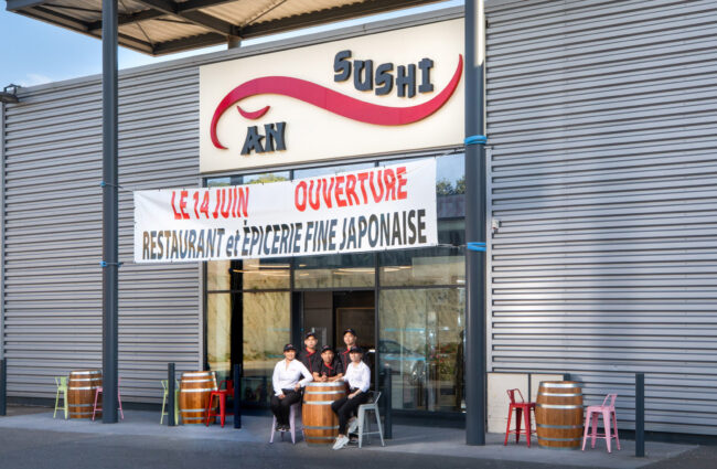Shooting culinaire pour le restaurant An Sushi 7 Devanture du restaurant An sushi avec le personnel assis en terrasse autour d'une barrique en bois.