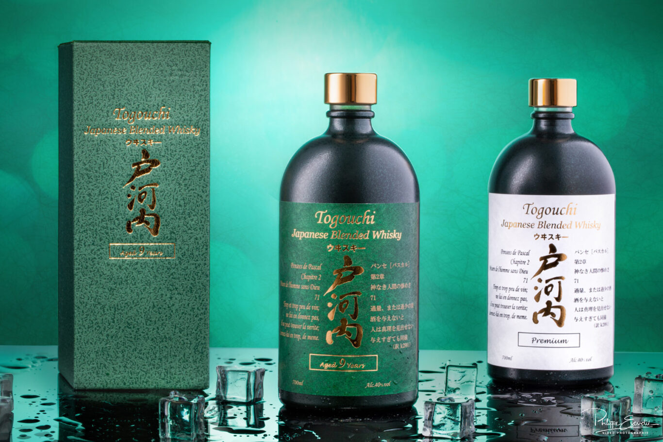 Deux Bouteilles de whisky japonais posées sur un fond noir avec des glaçons et des gouttes d’eau autour.