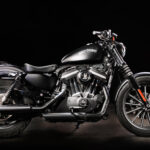 Une moto de marque Harley Davidson de profil sur fond noir