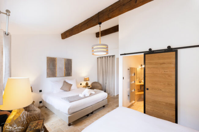Shooting immobilier, pour maisons d’hôtes, gîtes, hôtels, propriétaires ou conciergerie. 4 Vaste chambre aux murs blancs avec un lit et une salle de bain