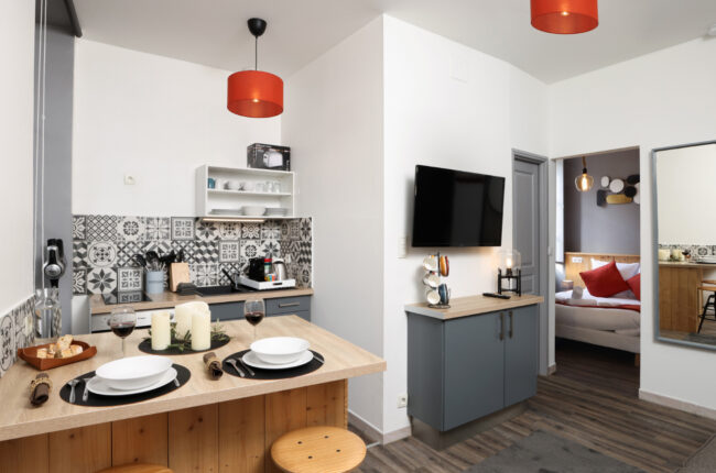 Shooting immobilier, pour maisons d’hôtes, gîtes, hôtels, propriétaires ou conciergerie. 7 Cuisine américaine avec une table dressée et deux verres de vin