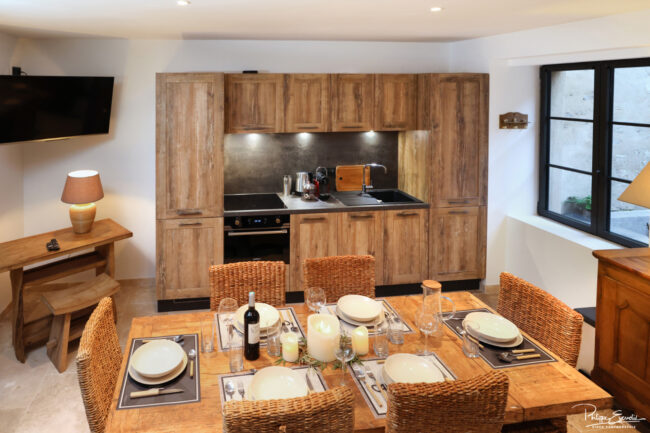 Shooting immobilier, pour maisons d’hôtes, gîtes, hôtels, propriétaires ou conciergerie. 6 Salon avec table dressée et cuisine en arrière-plan