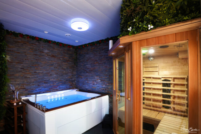 Shooting immobilier, pour maisons d’hôtes, gîtes, hôtels, propriétaires ou conciergerie. 8 Pièce aux murs de pierres apparentes avec à l’intérieur un jacuzzi et une cabine de sauna éclairée.