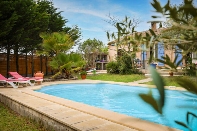 Shooting immobilier, pour maisons d’hôtes, gîtes, hôtels, propriétaires ou conciergerie. 11 Piscine d’extérieur remplie d’eau bleu et des branches d’olivier en premier plan.