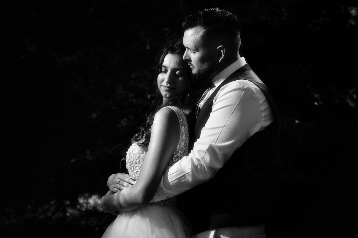 Photo en noir et blanc d'un couple de mariés enlacés de profil