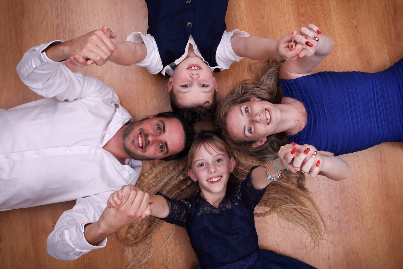 vue de dessus d'une famille composé du père de la mère du fils et de la fille se tenant tous pas la main