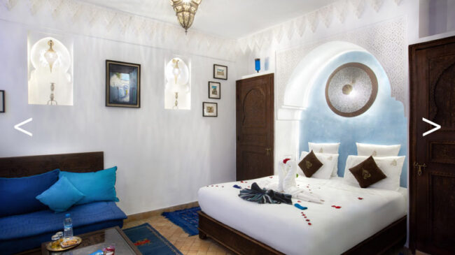 Intérieur cosy d'une chambre de riad comprenant un lit, un canapé, une table et une lampe