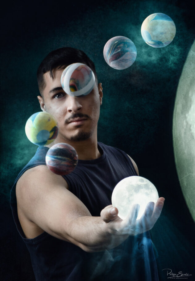 Jongleur tenant dans sa main une pleine lune en forme de balle avec s tout autour de lui d'autres balles symbolisant des planètes
