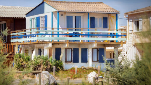 Chalet en bois blanc et bleu sur pilotis