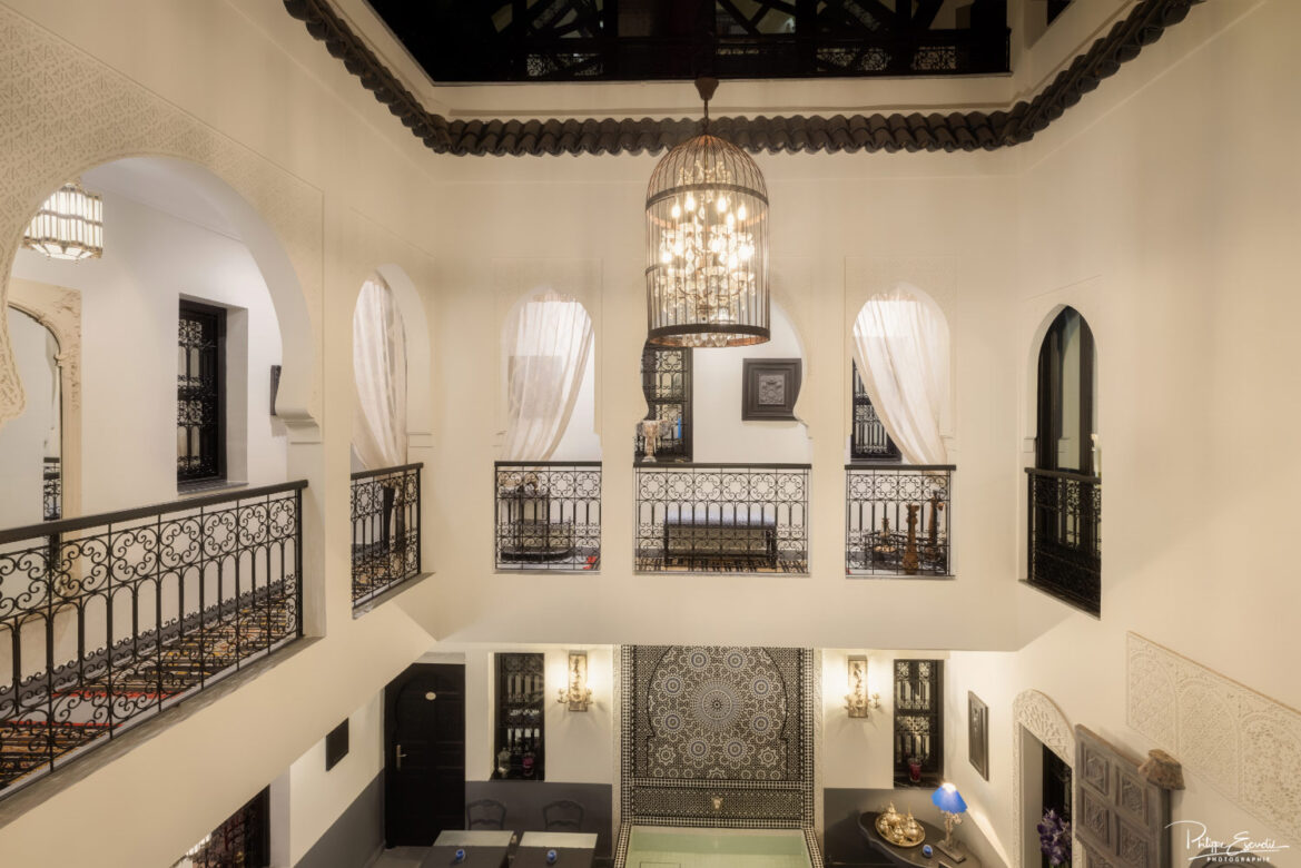 coursives de nuit d'un riad aux alcôves blanches.