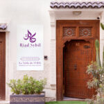 Deux portes anciennes orientales avec une pancarte entres les deux sur laquelle est inscrite Riad Sybil