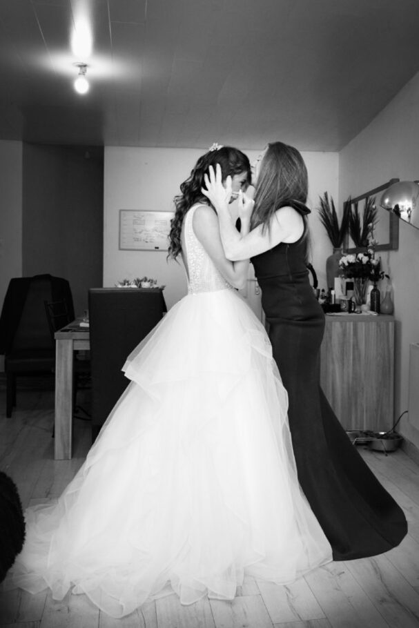 Une mère embrasse sa fille en tenue de mariée, photo noir et blanc